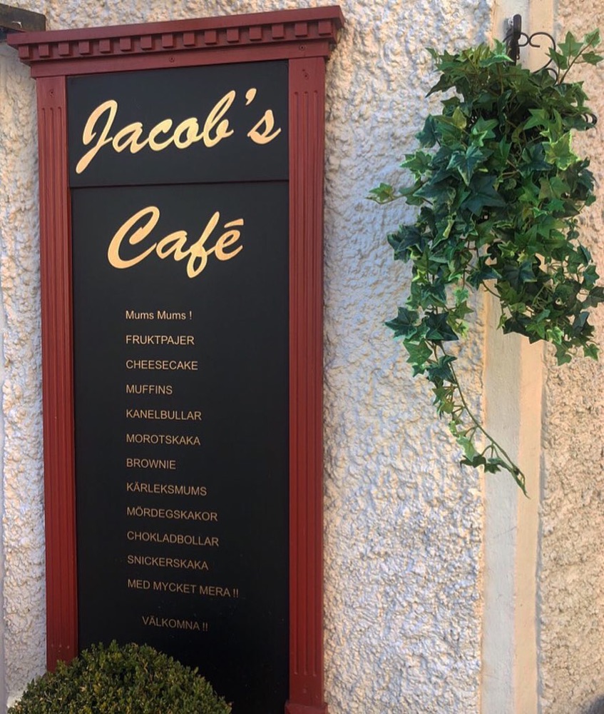 Skylten Jacob's Café med listan över kakor: fruktpajer, cheesecake, kanelbullar, morotskaka och mer